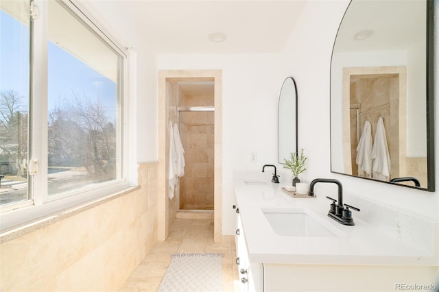 bathroom featuring double vanity, tile patterned flooring, a sink, and a shower stall