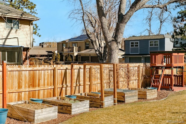 view of yard featuring a playground, a vegetable garden, a residential view, and fence