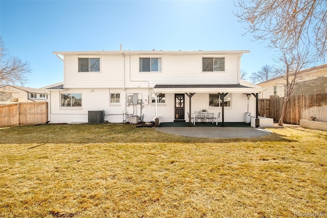 rear view of property featuring cooling unit, a patio area, a fenced backyard, and a yard