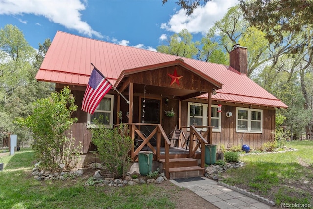 1638 County Road 46, Howard, CO 81233 - chalet / cabin with a chimney, metal roof, a front yard, and covered porch
