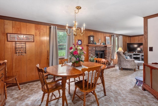 1638 County Road 46, Howard, CO 81233 - dining room featuring a brick fireplace, a chandelier, wooden walls, and light colored carpet