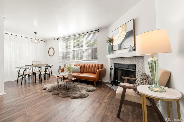 sitting room featuring a fireplace, baseboards, and wood finished floors