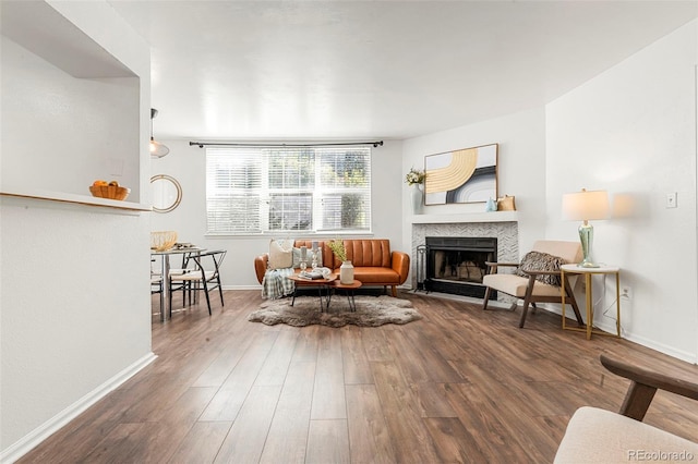 living area with a fireplace, wood finished floors, and baseboards