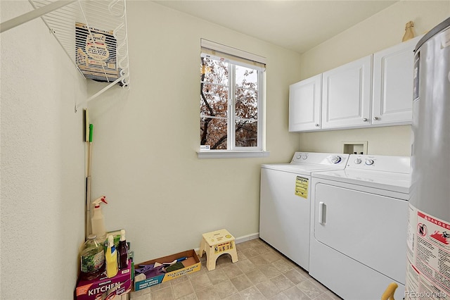 washroom with washer and clothes dryer, cabinets, and water heater