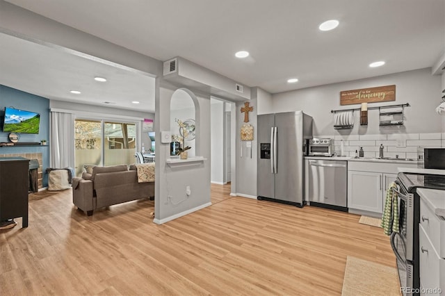 kitchen with light countertops, visible vents, a sink, light wood-type flooring, and appliances with stainless steel finishes