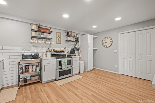 kitchen featuring open shelves, light wood-style floors, light countertops, and stainless steel appliances