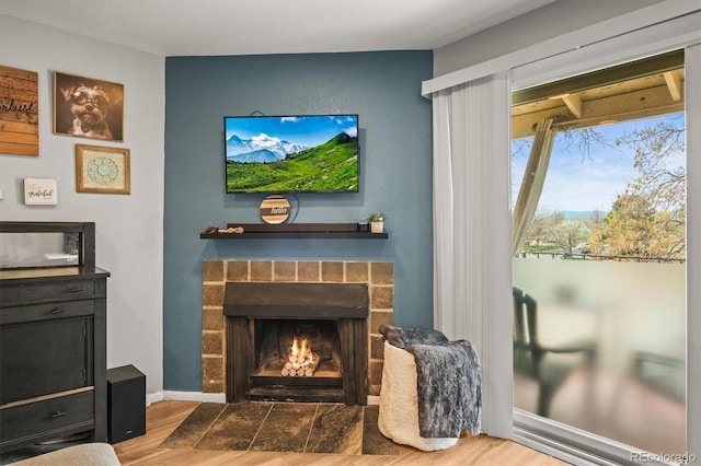 sitting room featuring a fireplace with flush hearth and wood finished floors