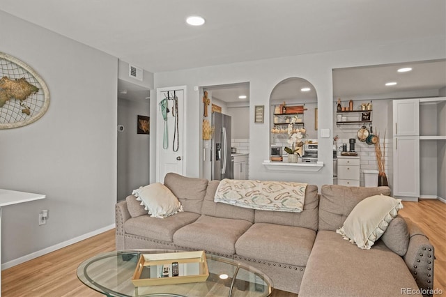 living room featuring baseboards, visible vents, recessed lighting, and light wood-style floors