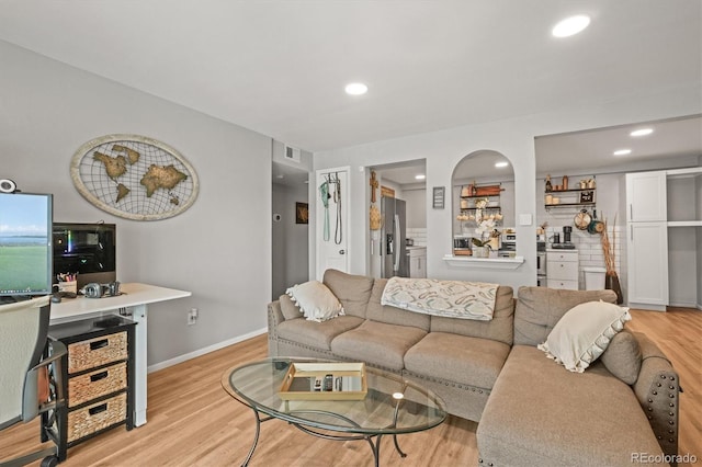living room with baseboards, visible vents, light wood finished floors, and recessed lighting