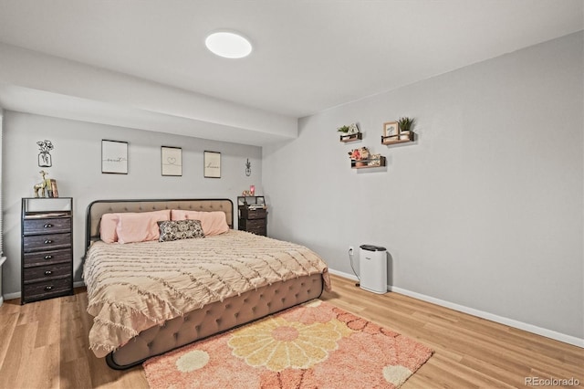 bedroom with baseboards and wood finished floors