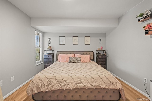 bedroom featuring light wood finished floors and baseboards