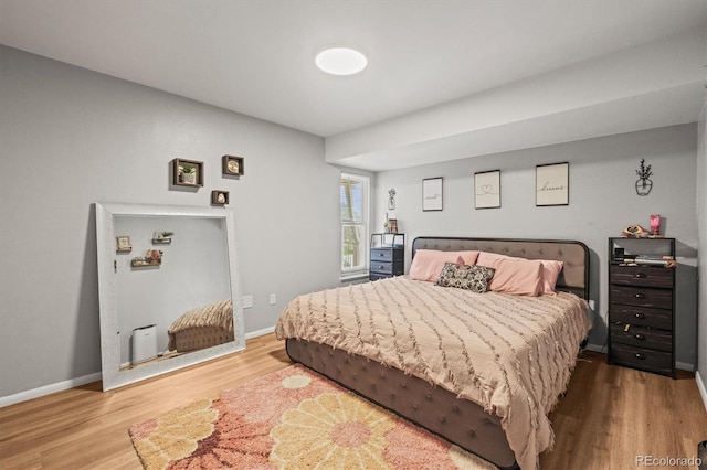 bedroom featuring wood finished floors and baseboards
