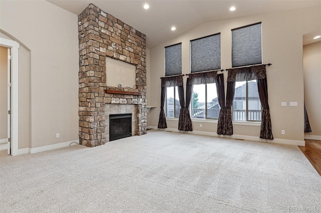 unfurnished living room with carpet, vaulted ceiling, and a fireplace