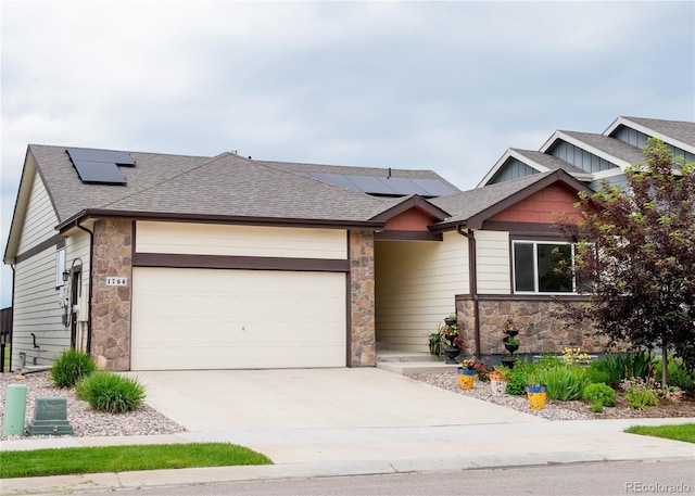 1766 Country Sun Dr, Windsor, CO 80550 - view of front of property with stone siding, roof mounted solar panels, a garage, and roof with shingles