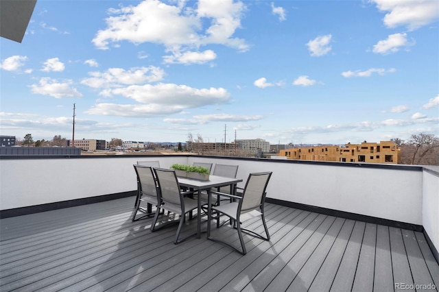 wooden deck with outdoor dining area and a city view