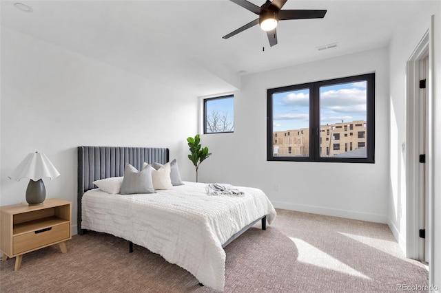 carpeted bedroom featuring a ceiling fan, visible vents, and baseboards