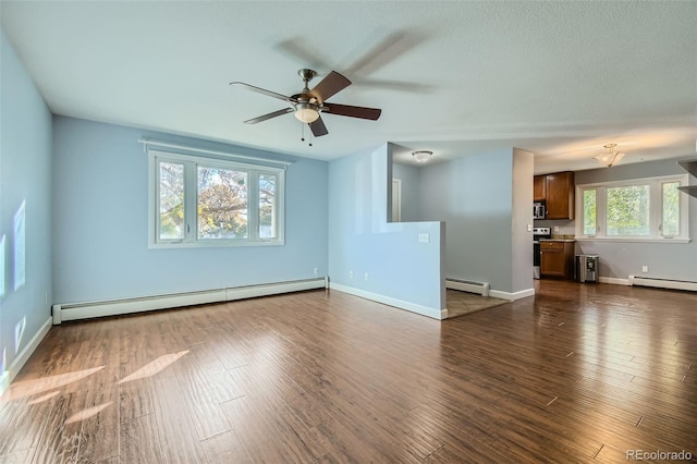 unfurnished living room with a baseboard heating unit, dark hardwood / wood-style floors, and a healthy amount of sunlight