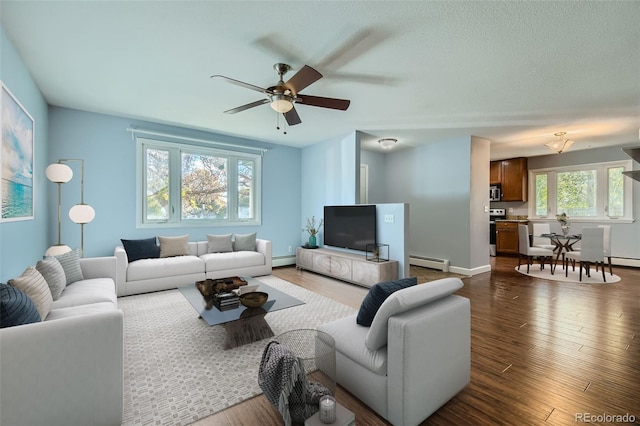 living room with a baseboard heating unit, dark hardwood / wood-style floors, and ceiling fan