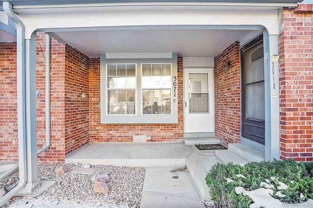 view of exterior entry featuring covered porch