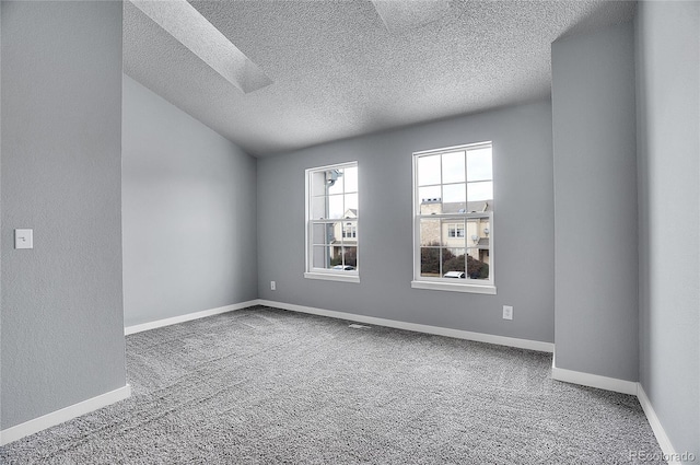 spare room featuring carpet flooring and a textured ceiling