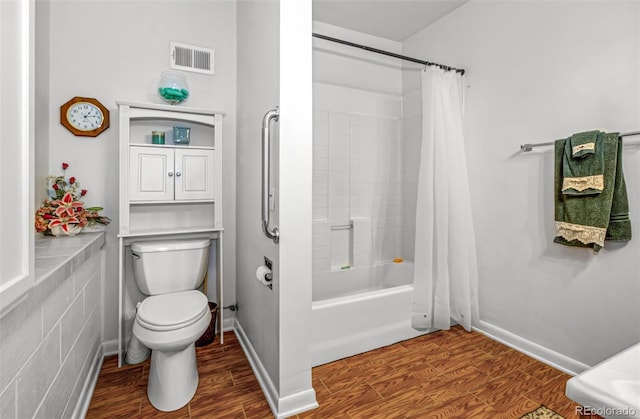 bathroom with shower / tub combo, hardwood / wood-style flooring, and toilet