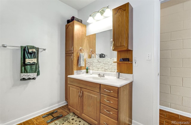 bathroom featuring vanity, wood-type flooring, and tasteful backsplash