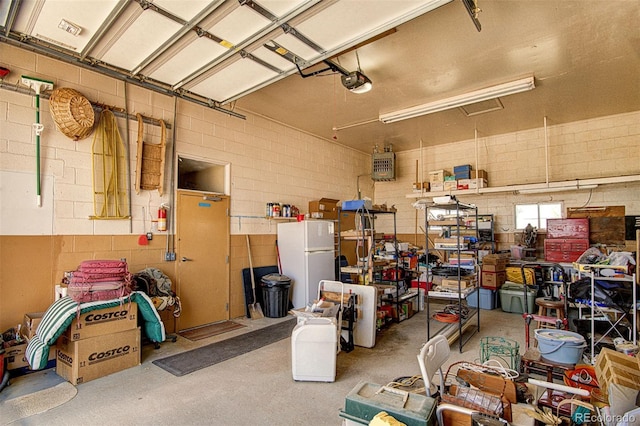 garage with white refrigerator and a garage door opener