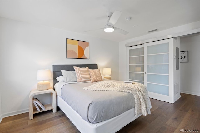 bedroom featuring baseboards, wood finished floors, visible vents, and ceiling fan