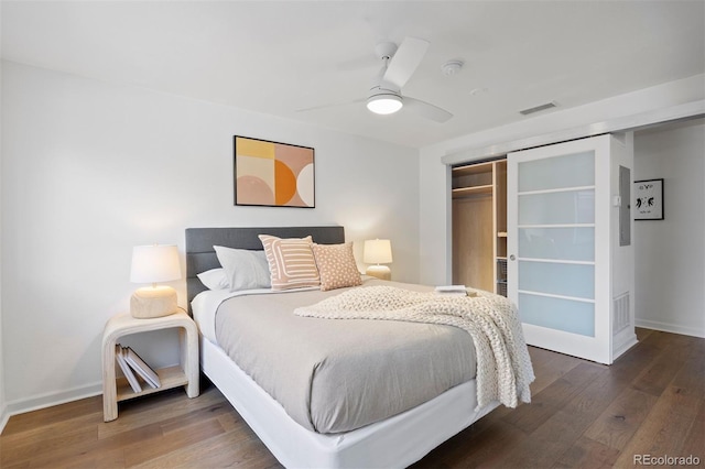 bedroom with visible vents, wood finished floors, a closet, baseboards, and ceiling fan