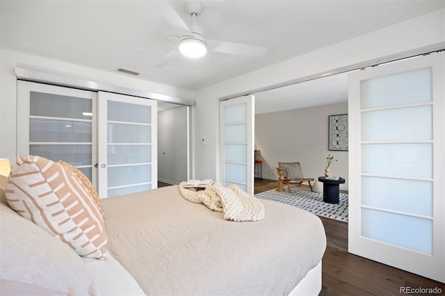 bedroom with a ceiling fan, visible vents, dark wood finished floors, french doors, and a closet