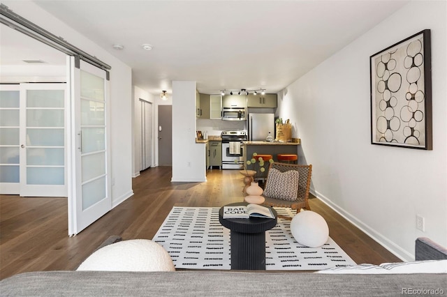 living room featuring track lighting, baseboards, and wood finished floors