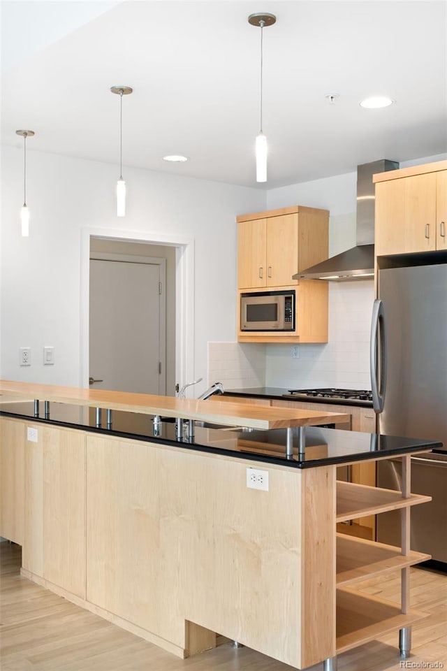 kitchen with stainless steel appliances, wall chimney range hood, light brown cabinets, light wood-style floors, and recessed lighting