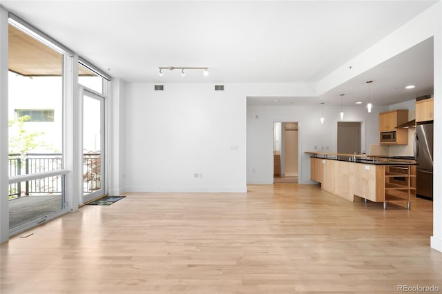 unfurnished living room featuring light wood-style floors and baseboards