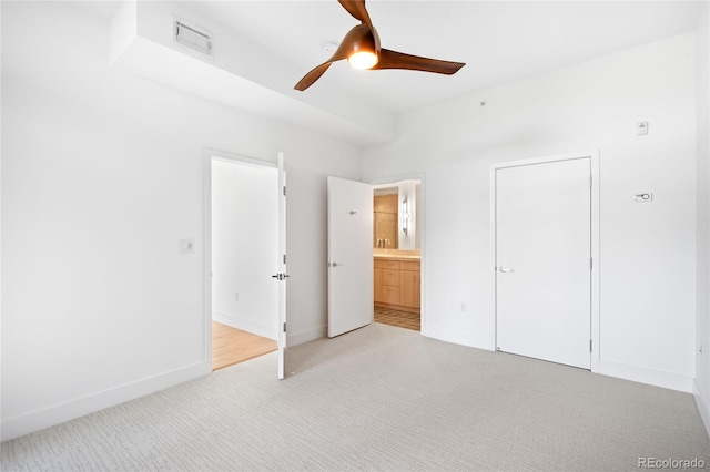 unfurnished bedroom featuring carpet flooring, baseboards, ensuite bathroom, and ceiling fan