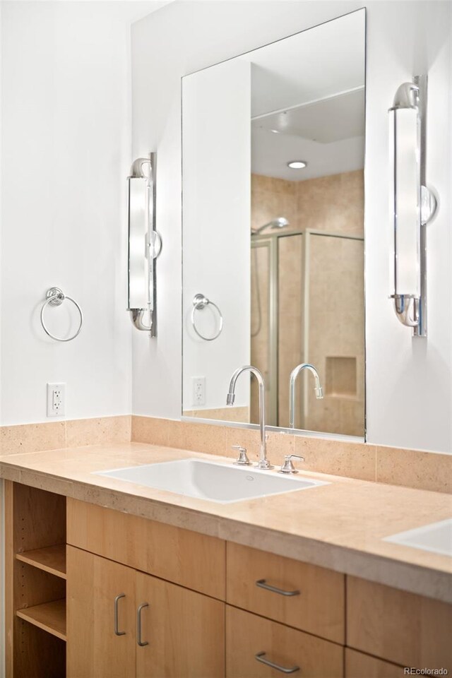 full bathroom featuring double vanity and a stall shower