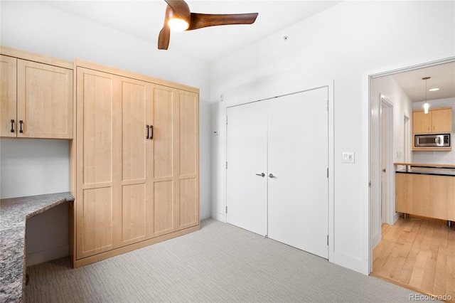 unfurnished bedroom with a closet, ceiling fan, and light carpet