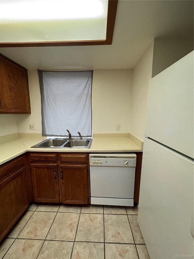 kitchen with light tile patterned flooring, white appliances, and sink