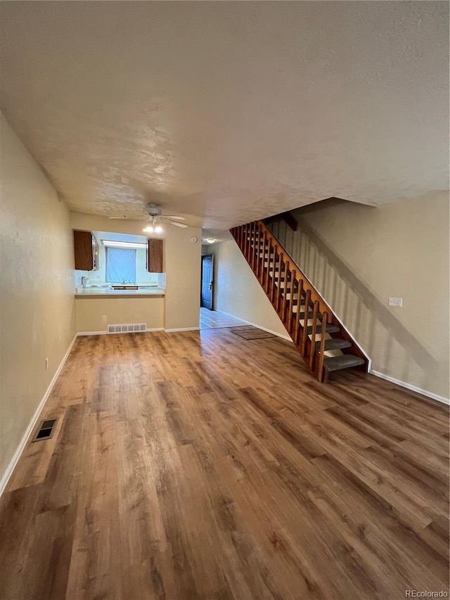 unfurnished living room with hardwood / wood-style floors and ceiling fan