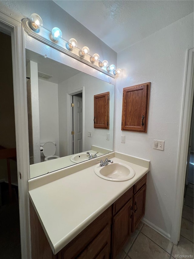 bathroom featuring tile patterned flooring, vanity, and toilet