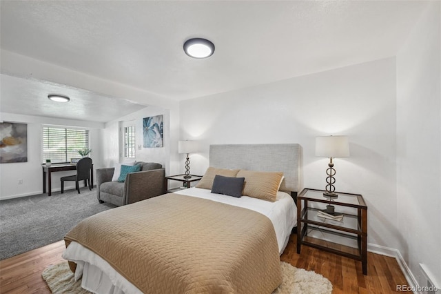 bedroom with baseboards and wood finished floors