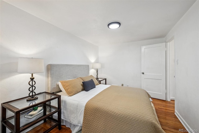 bedroom with wood finished floors and baseboards