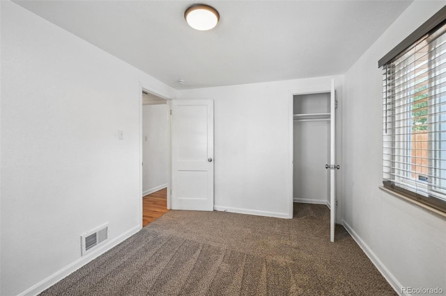 unfurnished bedroom with carpet flooring, a closet, and multiple windows
