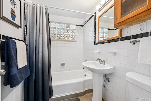 bathroom with tile walls, shower / tub combo, toilet, decorative backsplash, and a sink