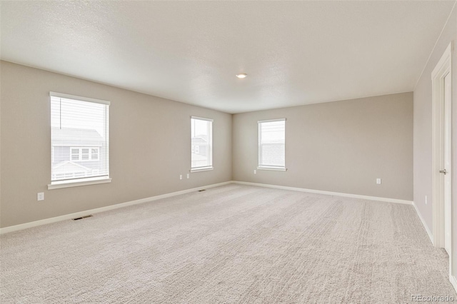 unfurnished room with light carpet and a textured ceiling