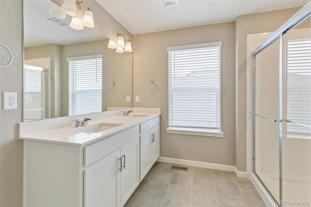 bathroom with tile patterned flooring, vanity, and walk in shower