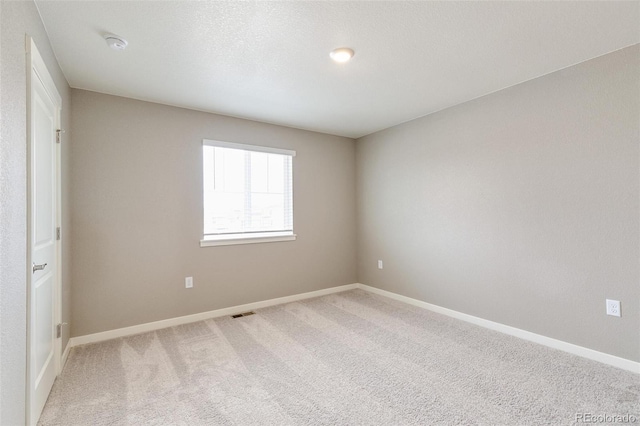 unfurnished room featuring carpet flooring and a textured ceiling