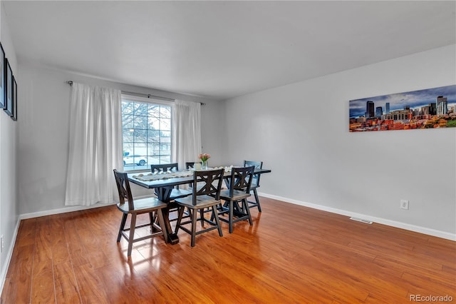 dining space featuring baseboards, visible vents, and light wood-style floors
