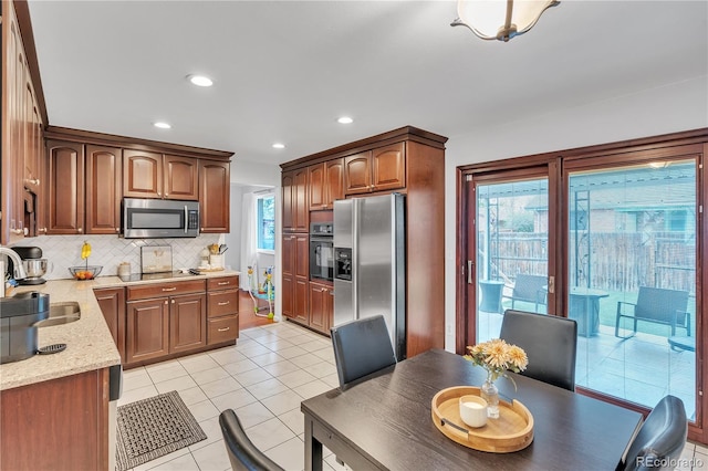 kitchen featuring a sink, recessed lighting, decorative backsplash, light tile patterned floors, and black appliances