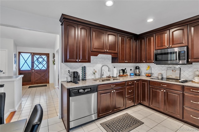 kitchen with a sink, light tile patterned floors, backsplash, and stainless steel appliances