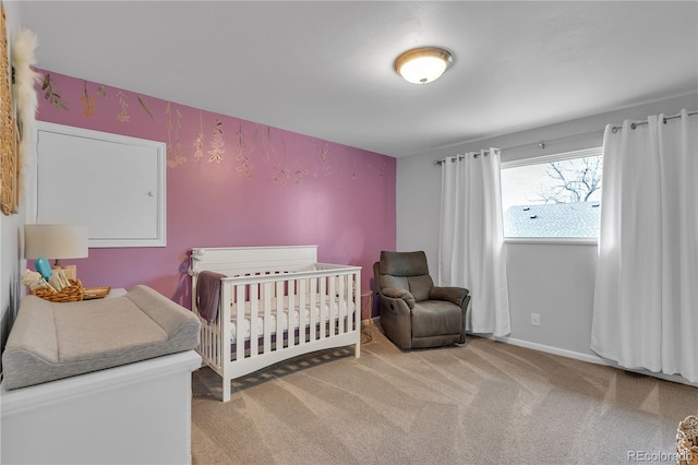 carpeted bedroom with baseboards and a nursery area